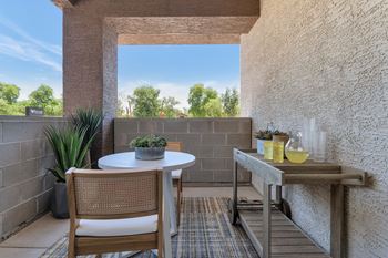 a patio with a table and chairs and a large window at Weylyn Luxury Apartments, Laveen, AZ, 85339